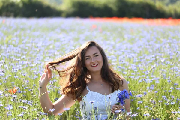 Retrato de uma jovem no campo azul cornflower — Fotografia de Stock