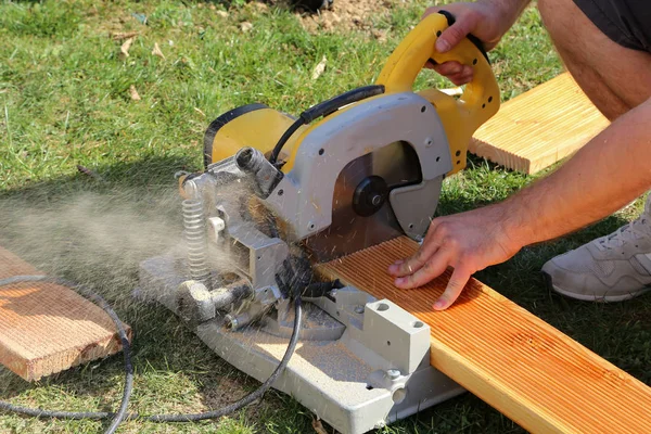 En arbetstagare såg trä med en Chop SAW — Stockfoto