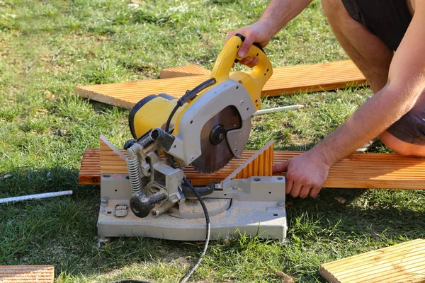 En arbetstagare såg trä med en Chop SAW — Stockfoto