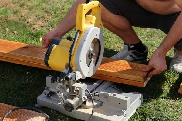 Un trabajador vio madera con una sierra de corte — Foto de Stock