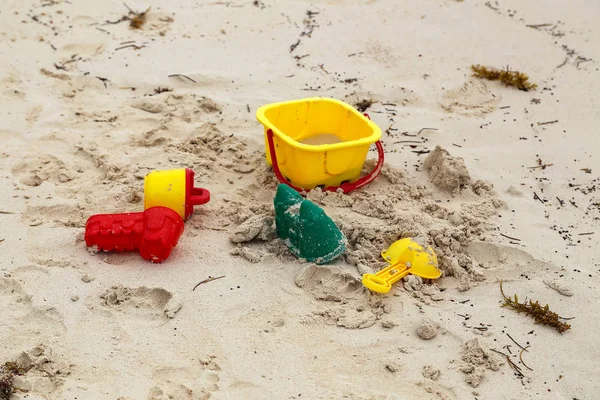 Brillantes juguetes de bebé yacen en la arena en la playa — Foto de Stock