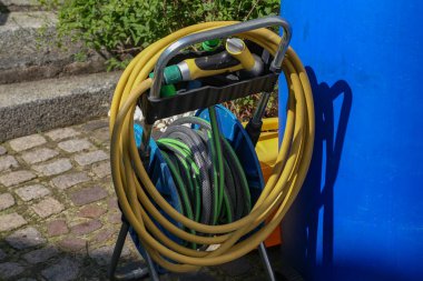 Sulama hortumları evin yakınındaki bahçede durmak