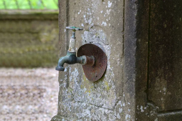 Alter rostiger Wasserhahn in der Hauswand — Stockfoto