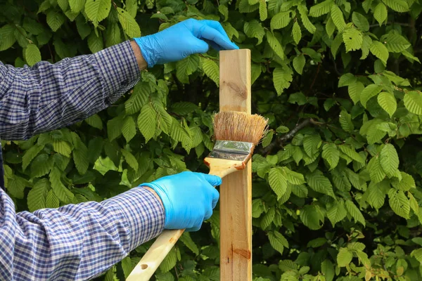 El trabajador pinta listones de madera con barniz protector — Foto de Stock