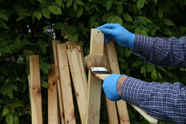 El trabajador pinta listones de madera con barniz protector — Foto de Stock