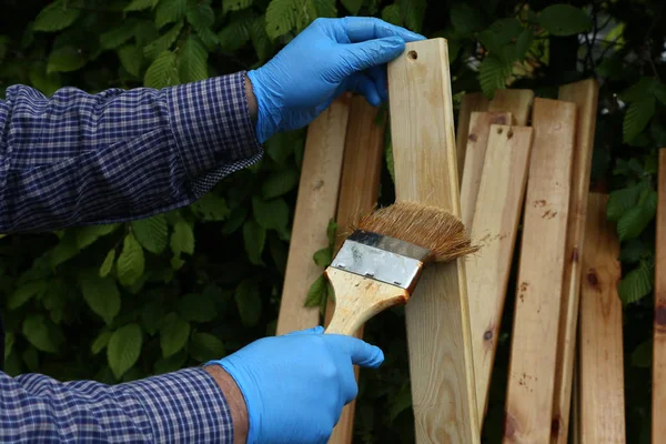 El trabajador pinta listones de madera con barniz protector — Foto de Stock