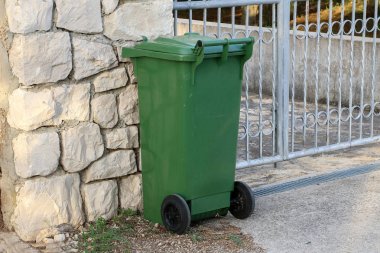 Yeşil çöp tenekesi kapıda duruyor