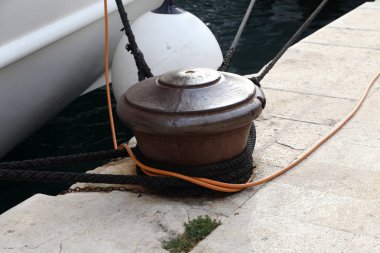 Etrafında bir demirleme halatı olan Bollard.