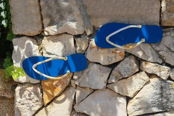 Sandalias pegadas a una pared de piedra — Foto de Stock