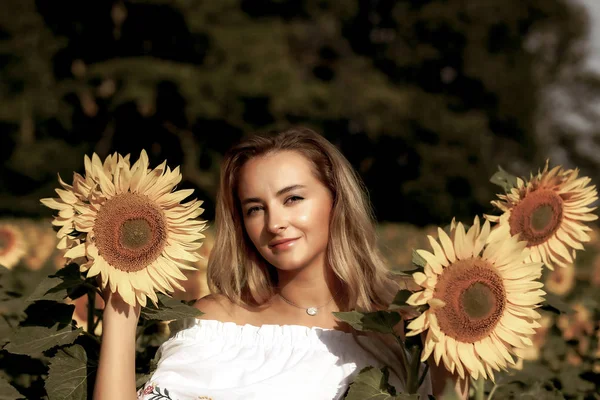 Menina bonito no campo cheio de girassóis — Fotografia de Stock