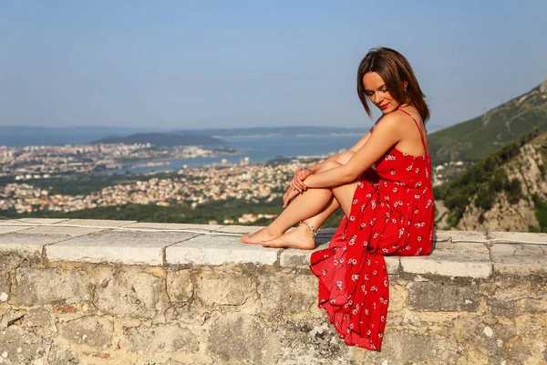 La fille est assise sur le mur de la forteresse — Photo