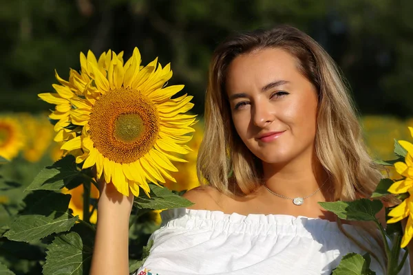 Ayçiçekleriyle dolu tarlada tatlı bir kız. — Stok fotoğraf