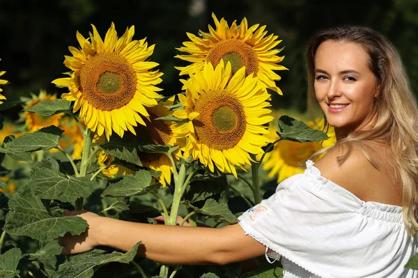 Ayçiçekleriyle dolu tarlada tatlı bir kız. — Stok fotoğraf