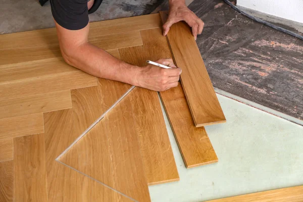 Worker laying parquet flooring. Worker installing wooden laminate flooring — Stock Photo, Image