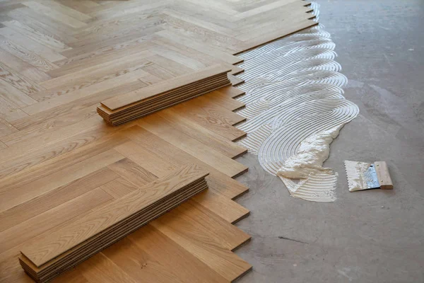 Worker laying parquet flooring. Worker installing wooden laminate flooring — Stock Photo, Image
