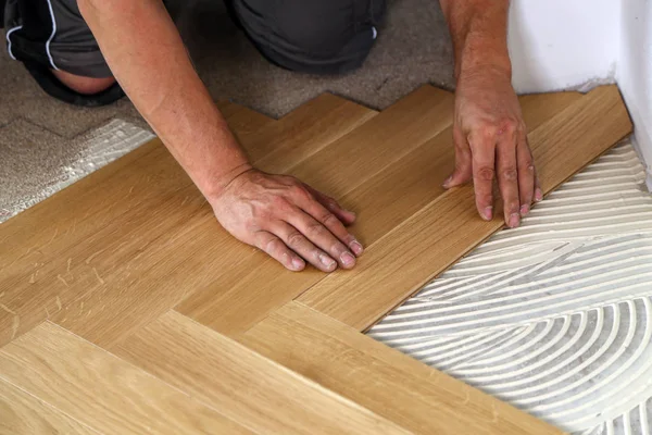 Worker laying parquet flooring. Worker installing wooden laminate flooring — Stock Photo, Image