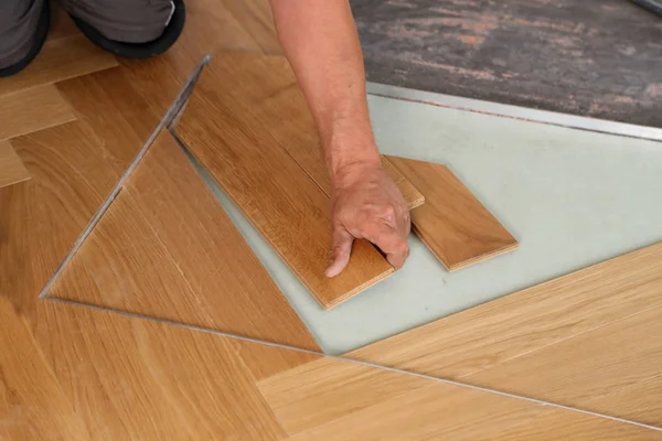 Worker laying parquet flooring. Worker installing wooden laminate flooring — Stock Photo, Image