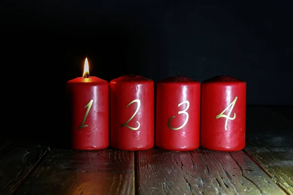 1.Advent. Le candele di Avvento rosse stanno su un pavimento di legno — Foto Stock