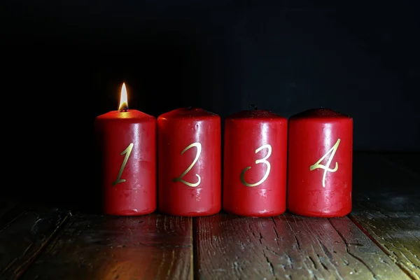 1. Advent. Rote Adventskerzen stehen auf einem Holzboden lizenzfreie Stockbilder