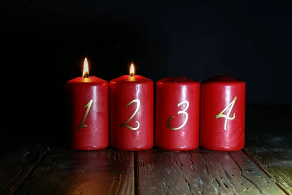 2. Advent. Rote Adventskerzen stehen auf einem Holzboden Stockbild