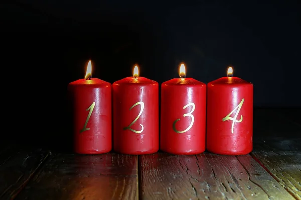 4. Advent. Rote Adventskerzen stehen auf einem Holzboden lizenzfreie Stockfotos