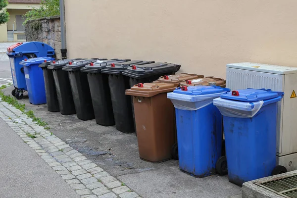 Various garbage cans stand on the street