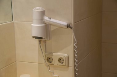 Duvara bağlı beyaz saç kurutma makinesi