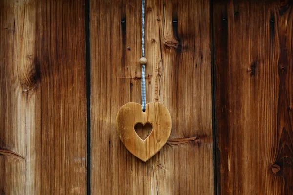 Drewniane serce dla szczęścia na drewnianych drzwiach — Zdjęcie stockowe
