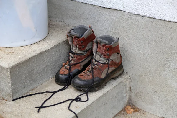 Sucios zapatos de pie en el porche de la casa —  Fotos de Stock