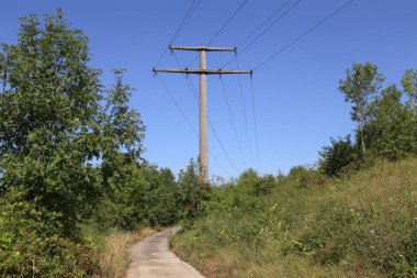 Güç iletimi açık mavi gökyüzüne doğru gidiyor.