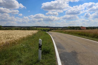 Mavi gökyüzü ve beyaz bulutlu yaz manzarası.