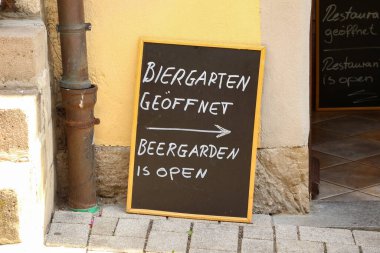 Sokakta bir plaket. Almanca ve İngilizce metin: Bira bahçesi açık.