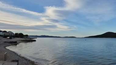 Yaz tatili konsepti için arka plan. Kumsalın ve denizin doğası, güneş ışığıyla yaz, kumlu sahil, köpüklü deniz suyu mavi gökyüzü ile çelişiyor.