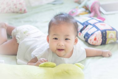 yatakta yatıyordu ve gülümseyen bir küçük bebek bebek