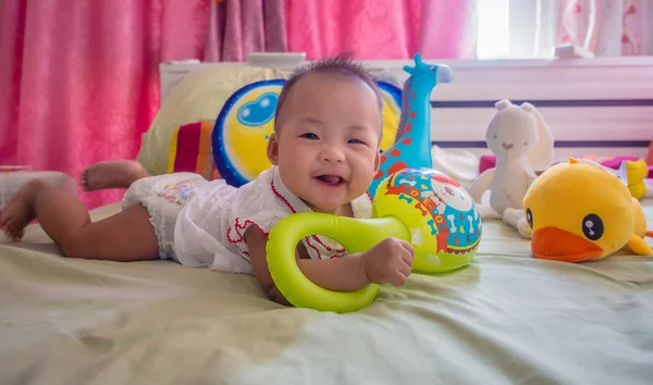 oyuncaklar yatağa oynama ve gülümseyen bir küçük bebek bebek