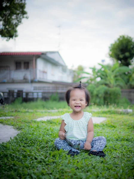 草の上に座って少し笑みを浮かべて赤ちゃん — ストック写真