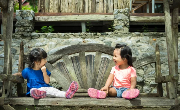 Dwie Dziewczyny Trochę Siedzieć Rozmawiając Drewnianej Ławce — Zdjęcie stockowe