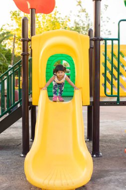 Yaz aylarında Bahçesi kaydırıcısında oynamak için küçük kız eğleniyor