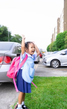 araba parkında hazır okula geri atlama sırt çantası ile mutlu küçük kız