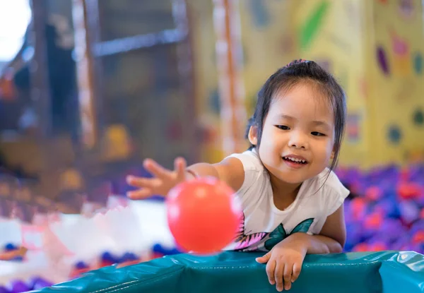 Asyalı küçük kız, bir çocuk oyun alanı içinde oynamaktan hoşlanıyor.