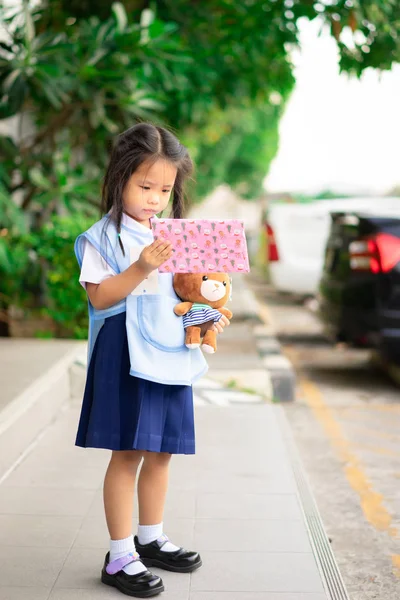 Trochę Asian Dziewczyna w Thai Szkoła Uniform Holding Gift Box i zrobić — Zdjęcie stockowe
