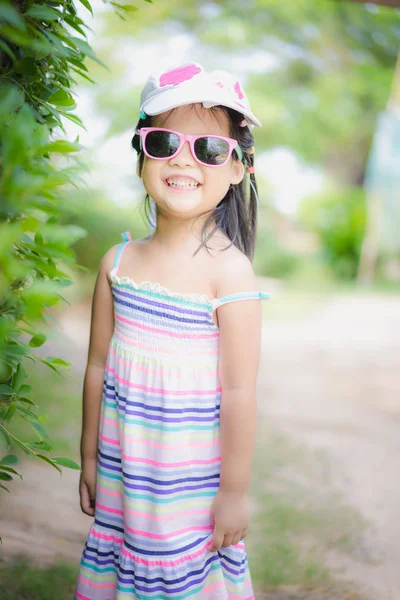 Portrait de mignon asiatique petite fille porter des lunettes de soleil et chapeau en th — Photo