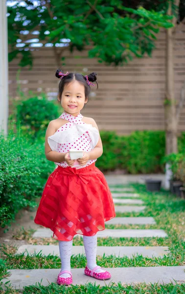 Portrait de mignonne petite fille en robe debout dans le parc — Photo