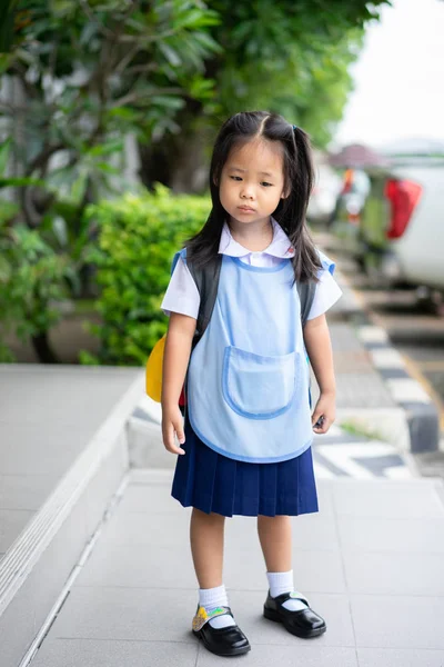 Ittle menina em tailandês escola uniforme não boa emoção de pé em t — Fotografia de Stock
