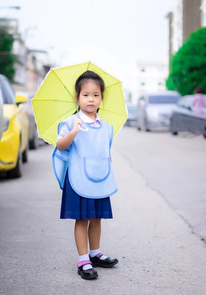 Petite fille avec parapluie debout dans le parking prêt à retourner à sch — Photo