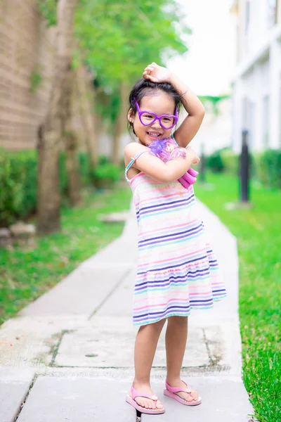 Portrait de heureux asiatique petite fille en robe debout sur footpat — Photo