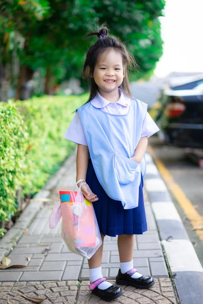 Portret szczęśliwej dziewczynki w szkole tajski mundur stojący na — Zdjęcie stockowe