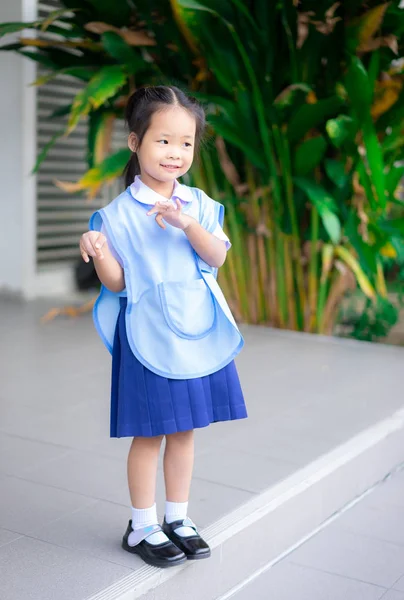 Portrait of happy little girl in Thai school uniform standing at — Stock Photo, Image