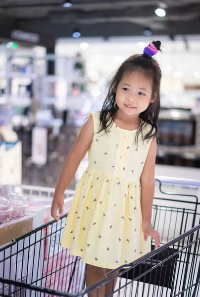 küçük asyalı kız alışveriş arasında sepeti ayakta