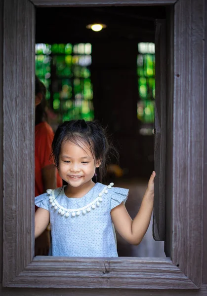 Счастливая маленькая девочка, стоящая у окна Стоковое Фото